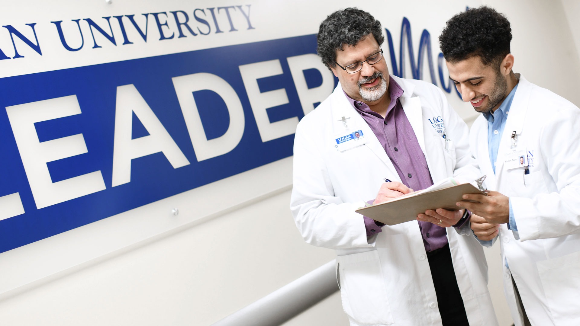 A Logan faculty clinician reviewing a care plan with a student doctor