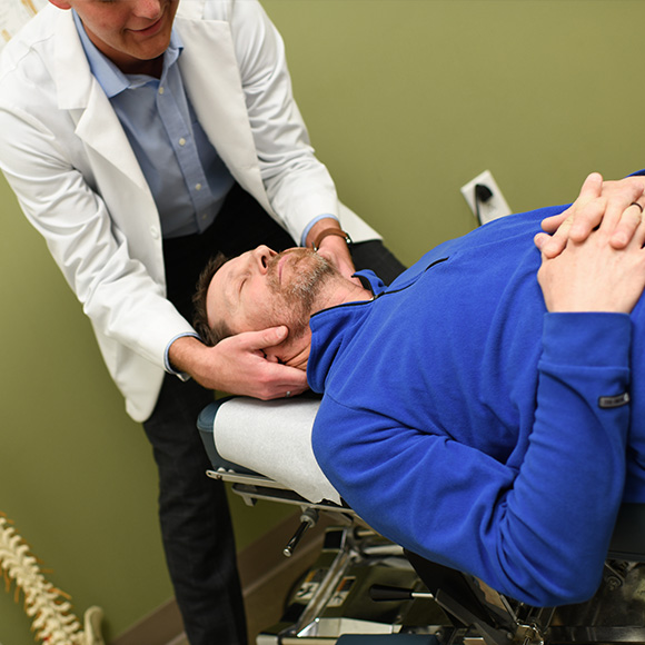 Chiropractor adjusting patient.